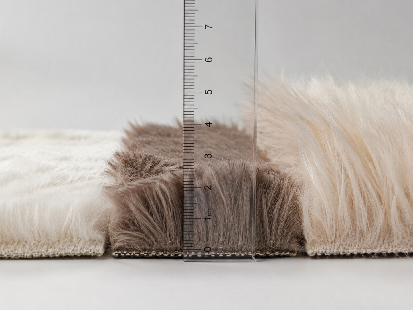 Faux fur blanket pile height measurement with ruler showing short, medium and long pile fabric