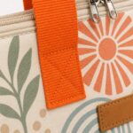 close up of orange webbing handle zipper pull stitching and original coastal printed fabric texture