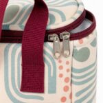 close up of burgundy zipper handle stitching padded piping and sea glass geometric printed canvas
