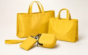 Yellow foldable reusable shopping bag set with two open bags and compact storage pouches