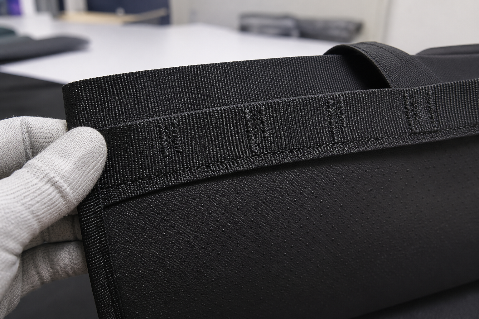 Reinforced webbing and bar-tack stitching on a dog car backseat extender Close-up of webbing-to-body construction, reinforced bar-tack stitching and anti-slip underside on a dog car backseat extender